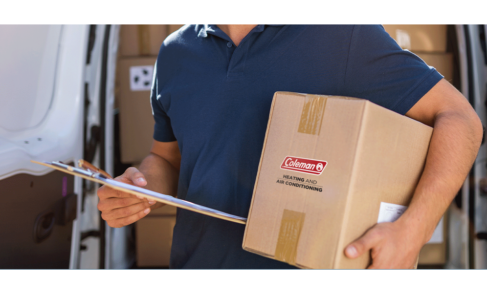 Man holding a cardboard box with the Coleman logo under his arm